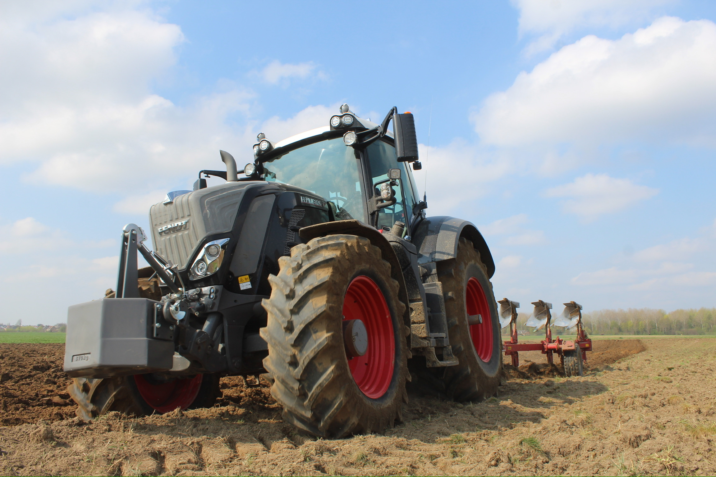 Loonwerker ploegen met tractor